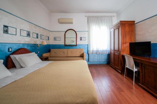a hotel room with a large bed and a desk at Hotel Diana in Ravenna