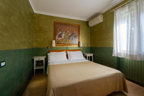 a bedroom with a bed with a painting on the wall at Hotel Diana in Ravenna