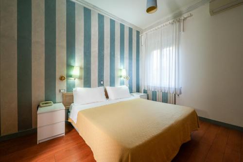a bedroom with a large bed and a window at Hotel Diana in Ravenna