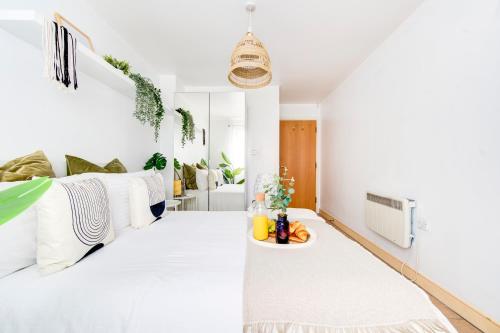 a white room with a bed and a table at BOHO Chic Tower Bridge Gem, Sleeps 8 in London