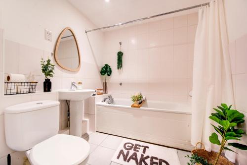 een badkamer met een toilet, een bad en een wastafel bij BOHO Chic Tower Bridge Gem, Sleeps 8 in Londen