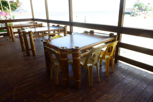 mesa y sillas en una habitación con ventana en The Beach Park Hadsan en Lapu Lapu City