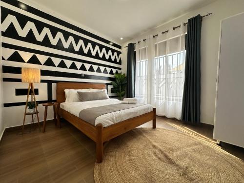 1 dormitorio con 1 cama con pared en blanco y negro en Coalescence Hotel Rwanda en Kigali