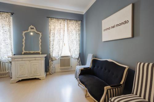 a living room with a chair and a mirror at Palazzo Dalla Rosa Prati in Parma