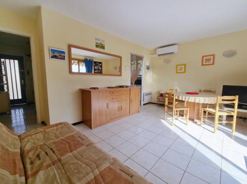 un salon avec une table et une cuisine dans l'établissement Les Hippocampes - T2 avec clim et parking, au Lavandou