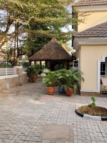 a gazebo in a yard with plants at Dazzle Hotels and Apartments Riverpark in Rubuchi