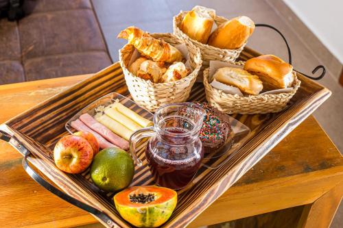 ein Tablett mit verschiedenen Brotsorten und Gebäck auf einem Tisch in der Unterkunft Chalés Belo Vale - Tiradentes in Tiradentes