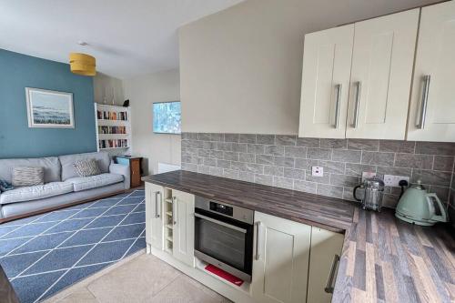 een keuken met witte kasten en een woonkamer bij Charming Character House in Beautiful Neighborhood in Belfast