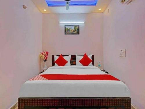a bedroom with a large bed with red pillows at OYO Hotel silver stone in Najafgarh