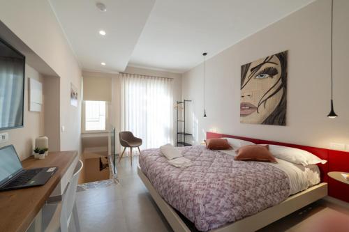 陶爾米納的住宿－TaoEtna Guest House, Taormina，一间卧室配有一张床和一张带笔记本电脑的书桌