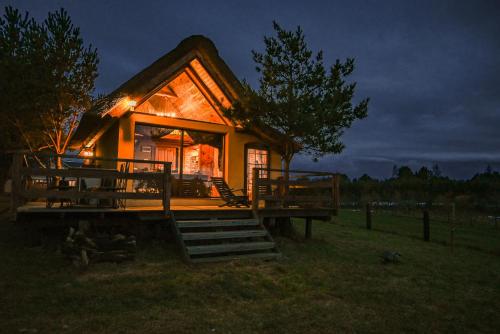 a small log cabin with a porch and a window at Ptasia Osada in Gardna Wielka