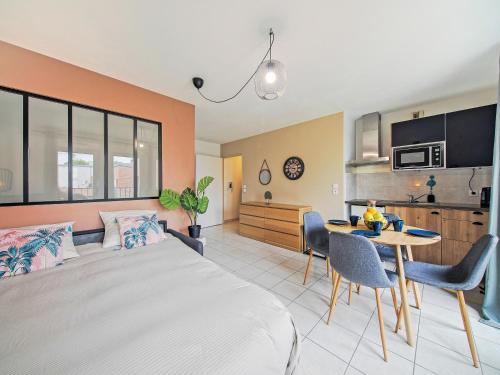 une chambre avec un lit et une table et une cuisine dans l'établissement Prague - 10min de Disneyland Paris Parking privé, à Montévrain