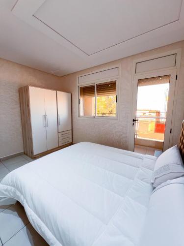a large white bed in a room with a window at Royal Rif Alhoceima in Al Hoceïma