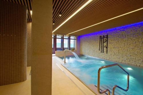 a large swimming pool with blue lights in a building at Resort Levočská Dolina in Levoča