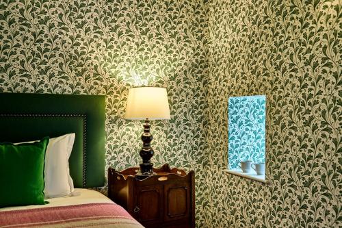 a bedroom with a bed and a lamp and a mirror at The Black Horse, Climping in Climping