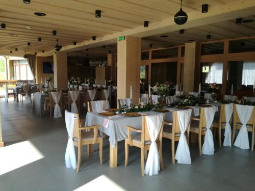 un salón de banquetes con mesas blancas y sillas con flores en Resort Levočská Dolina, en Levoča
