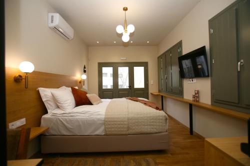 a bedroom with a bed and a flat screen tv at Living Yard Acropolis in Athens