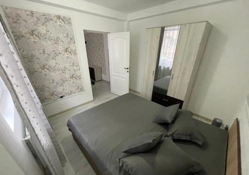 a bedroom with a bed and a mirror at R.M Apartament in Lugoj