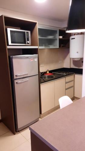 a kitchen with a refrigerator and a microwave at MODERNO MONOAMBIENTE CALIDAD SUPERIOR in Sunchales