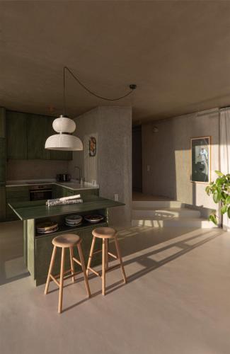 a kitchen with a green counter and two stools at LASPI / PETRES in Pefkali