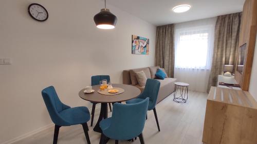 - un salon avec une table et des chaises bleues dans l'établissement Apartmány U Zámečku, à Kyjov