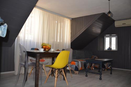 a dining room with a table and yellow chairs at Largo apartment in the heart of Diocletian palace in Split