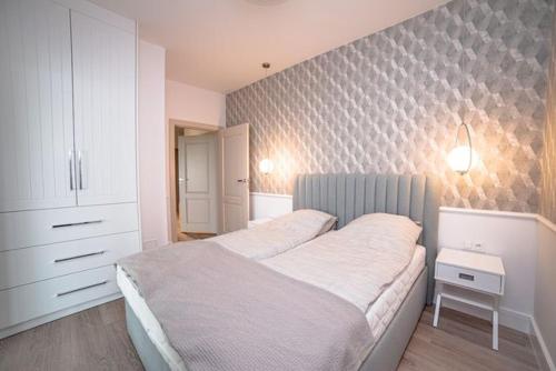 a bedroom with a large bed and a wall at Chill Nautica in Giżycko