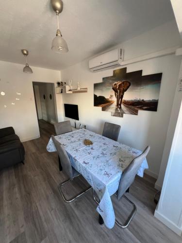 ein Esszimmer mit einem Tisch und einem Gemälde an der Wand in der Unterkunft Apartamento en Zaragoza junto a la Estación Delicias in Saragossa