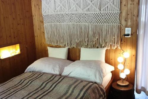 a bedroom with a bed with a large headboard at Drop In mountain chalet 