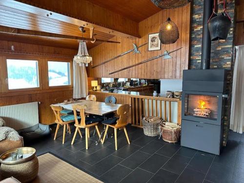 a dining room with a table and a fireplace at Drop In mountain chalet 