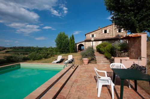 a pool with chairs and a house in the background at Villa degli Artisti by Mmega in Canonica