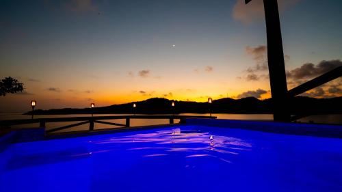 una piscina con vistas a la puesta de sol. en El Palacio Rosa on Blue Lagoon 3BR Beachfront Suite on pristine & quiet bay w incredible views, en Arrozal