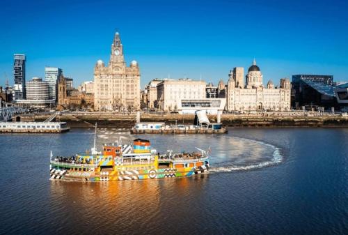 un gran barco en el agua cerca de una ciudad en Anfield end terraced home en Liverpool