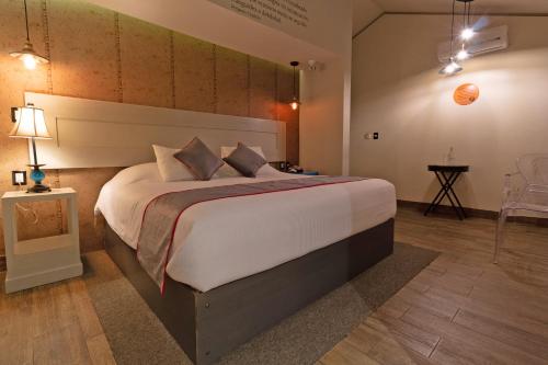 a bedroom with a large bed in a room at Collection O Coraz&oacute;n Del Caf&eacute; Hotel Boutique in Comit&aacute;n de Dom&iacute;nguez