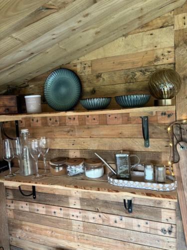 a wooden shelf with bowls and plates on it at The Deer Hut at Carr House Farm in Scarborough