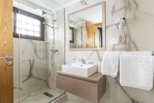 a bathroom with a sink and a shower at Hotel Mamora Kénitra in Kenitra