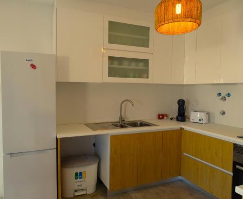 a kitchen with white cabinets and a sink at CASA DO TOMILHO by Stay in Alentejo in Vila Nova de Milfontes