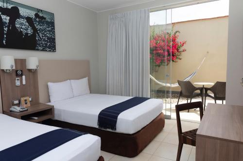 a hotel room with two beds and a table at Casa Andina Select Zorritos Tumbes in Zorritos