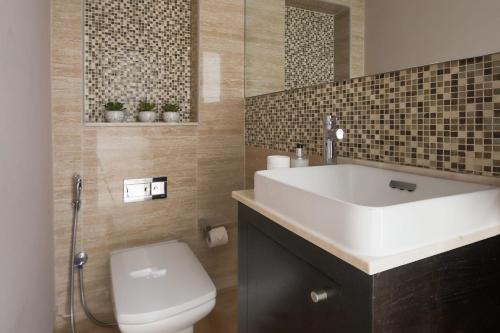 uma casa de banho com um lavatório branco e um WC. em Frank Porter - Mon Reve no Dubai