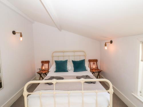 a bedroom with a white bed with two blue pillows at Secret Cottage, Southwold in Southwold