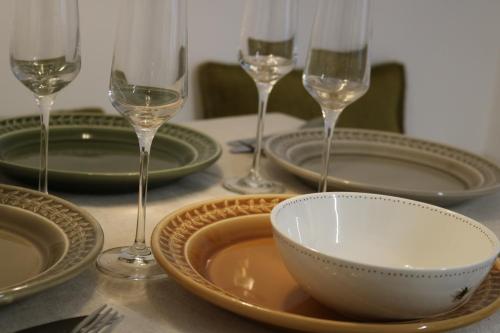 a table with plates and wine glasses and a bowl at Hectors house in Ormesby Saint Michael