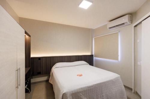 a small room with a bed and a window at Tonello Business Hotel in Campo Mourão