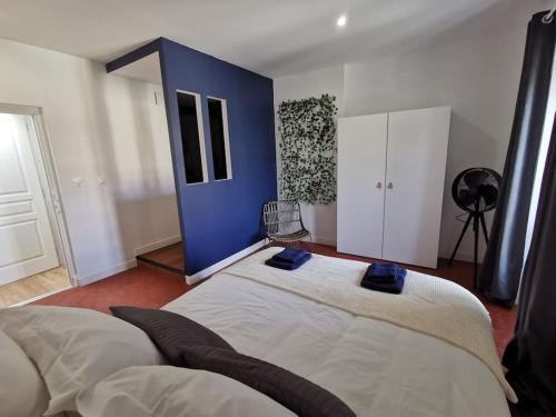 une chambre avec deux lits et un mur bleu dans l'établissement Soleil poudré appartement 1 chambre, pièce de vie climatisée, parking, terrasse, à Villeneuve-lès-Avignon