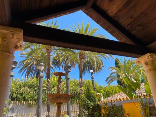 a view of palm trees from a porch at Cortijo La Saleta Banús in Marbella