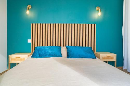 a bedroom with a large bed with blue walls at Appartement avec vue mer panoramique in Toulon