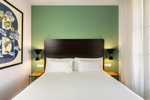 a bed in a room with a large white bed at Praktik Garden in Barcelona