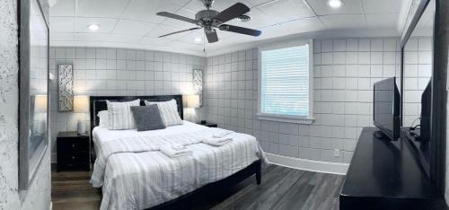 een slaapkamer met een bed en een plafondventilator bij Amazing Cottage - Located on Blue Mile - Close to GSU! in Statesboro