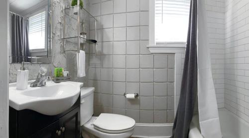 een witte badkamer met een wastafel en een toilet bij Amazing Cottage - Located on Blue Mile - Close to GSU! in Statesboro