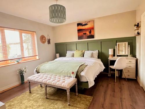 a bedroom with a bed and a desk and a chair at The Starlings Country House in Wexford
