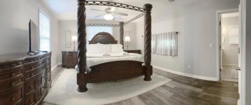 a bedroom with a canopy bed and a dresser at The Cottage House on the Blue Mile - Family Friendly, Close to GSU! in Statesboro